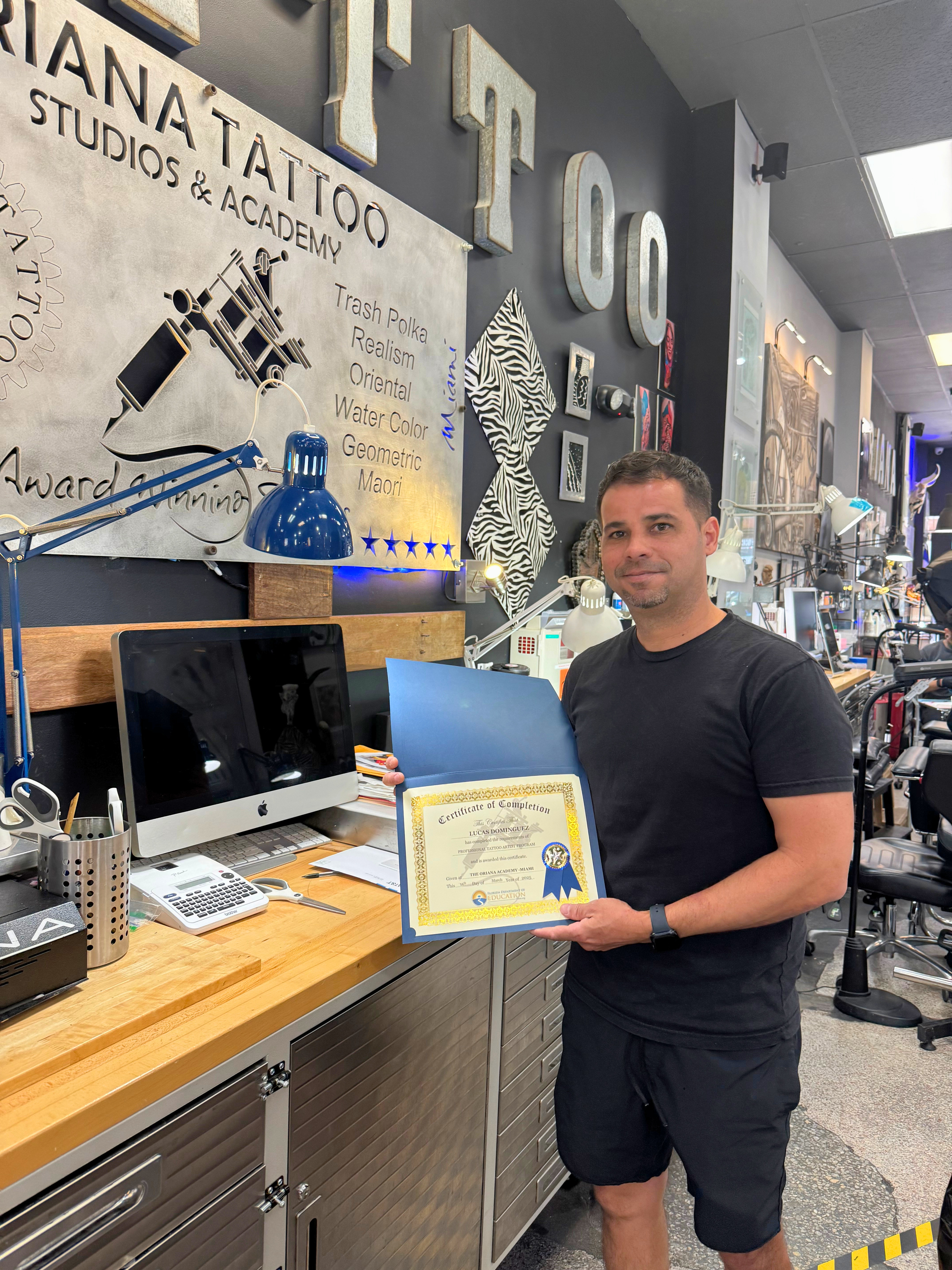 Graduate holding Oriana Academy certificate